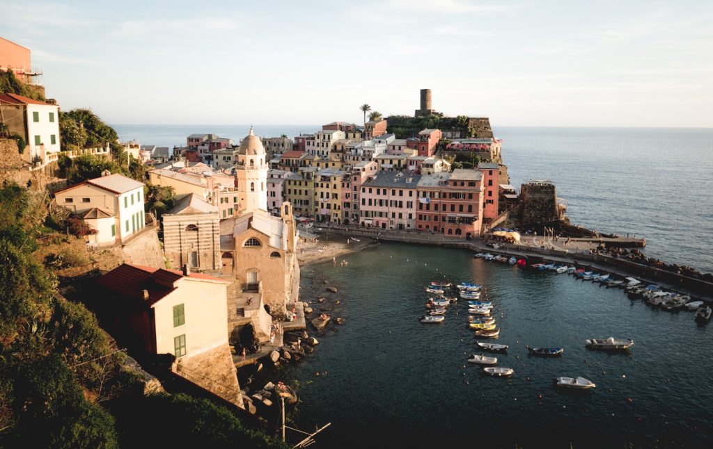 aerial view of rustic buildings sitting in a harbour of one of italy’s islands