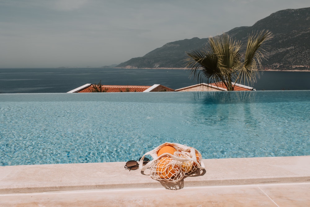 infinity pool overlooking the sea with a netted bag full of oranges 