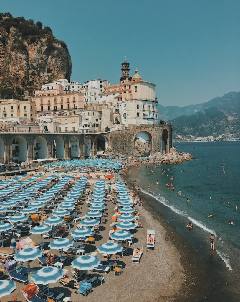sandy beach next to a set of luxury italian villas