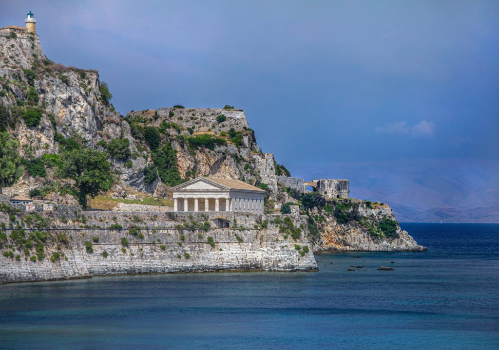 A classic greek temple on the tree dotted cliff edge of an Ionian or Sporades Island.