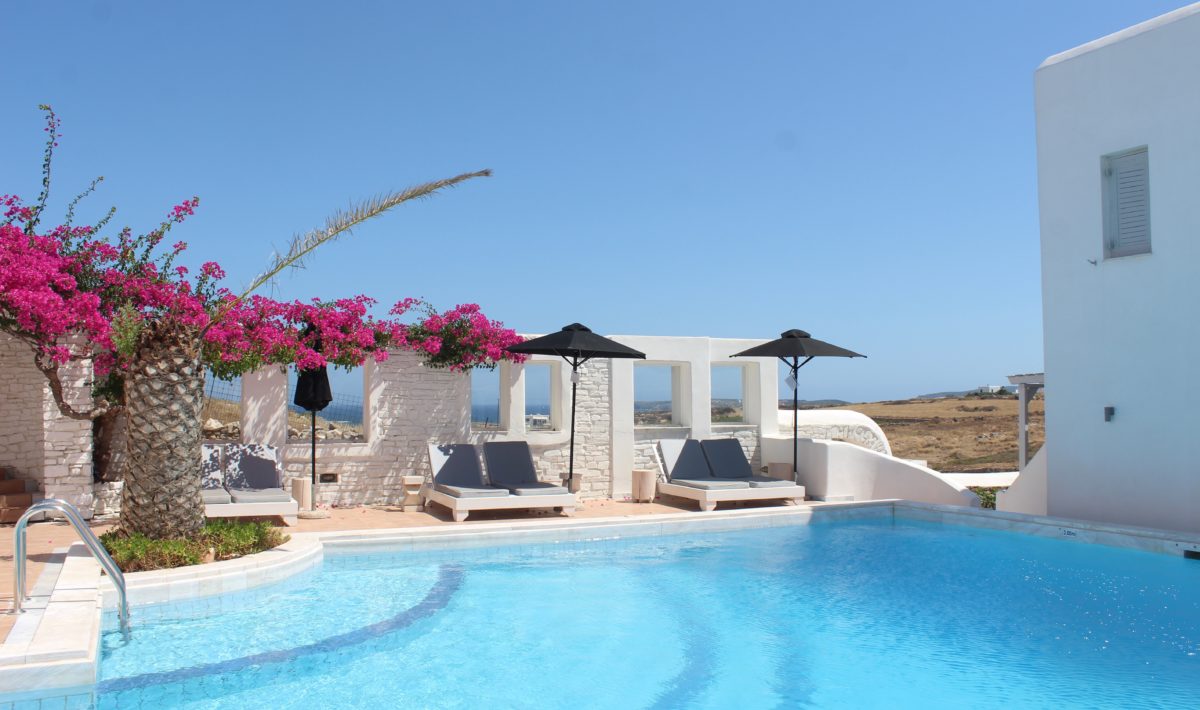 Clear blue pool water and azure sky contrasts with whitewashed bricks of a Greek villa 90 minutes from an airport.